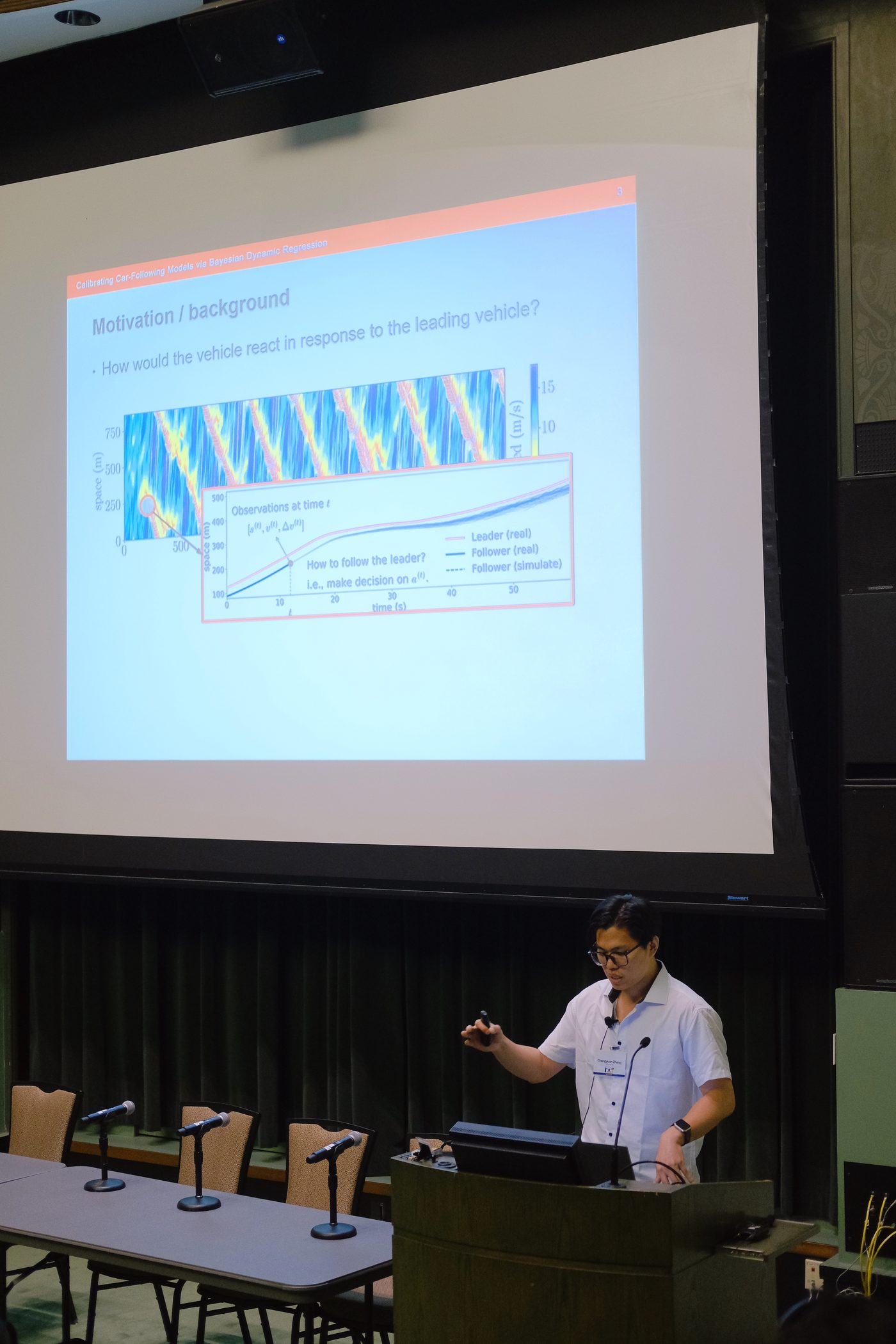 Chengyuan Zhang presenting at ISTTT25 in Ann Arbor, with car-following slides projected behind him